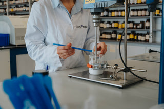 Apotheker Julie mengt grondstoffen van cosmetisch product in het laboratorium