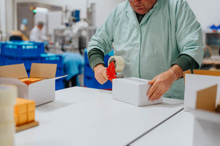 Maatwerker sluit verpakte doos JUGE producten met taperoller